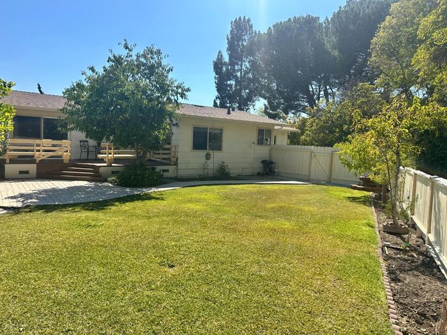 a blue swimming pool is sitting in the backyard of house