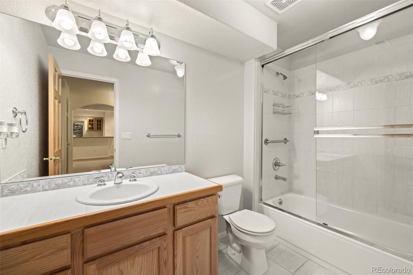 4141 South Hampton Circle Boulder, CO 80301 - Photo 31 of 35 a bathroom with a sink a toilet a mirror and shower