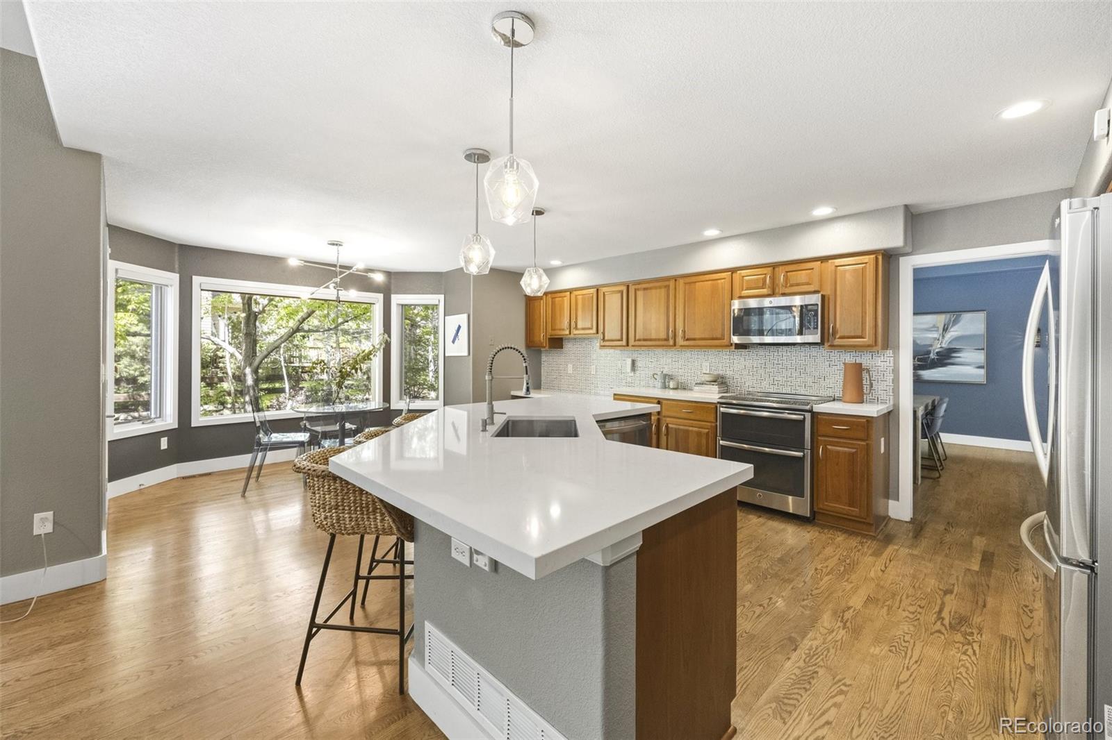 4141 South Hampton Circle Boulder, CO 80301 - Photo 7 of 35 a kitchen with a stove a refrigerator a sink dishwasher with a dining table and chairs