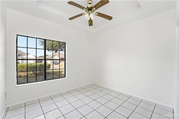 an empty room with windows and fan