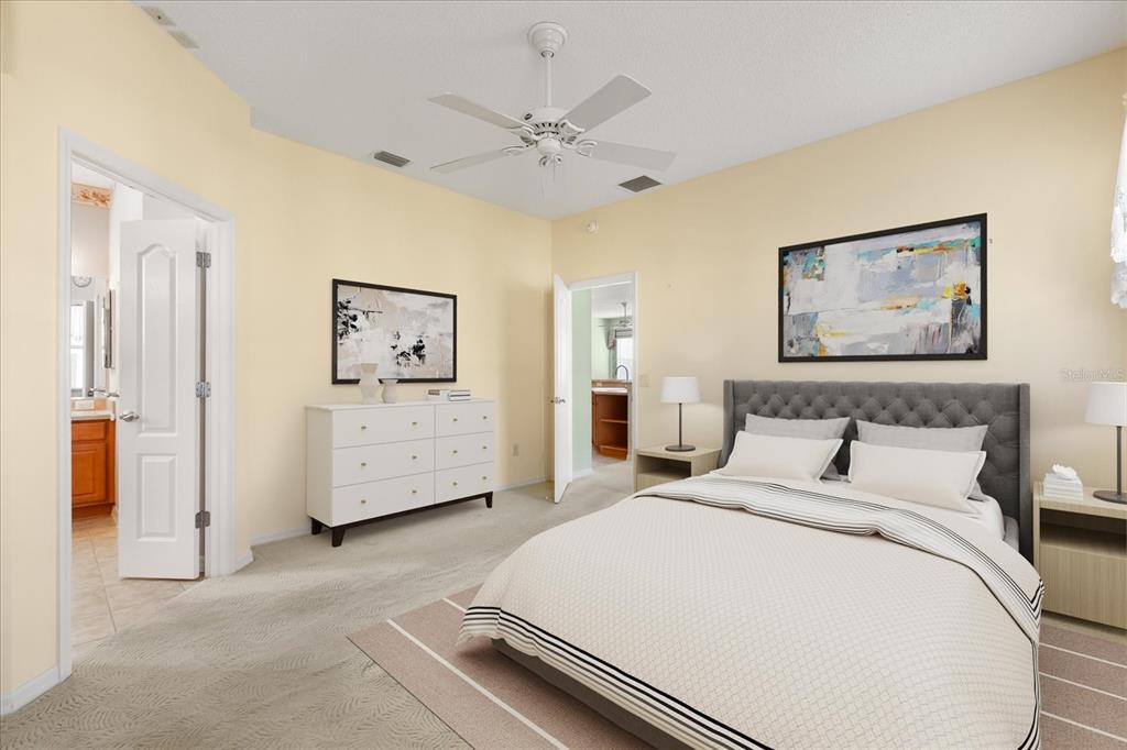 1424 Irwin Way The Villages, FL 32162 - Photo 11 of 28 a bedroom with a large bed and a chandelier