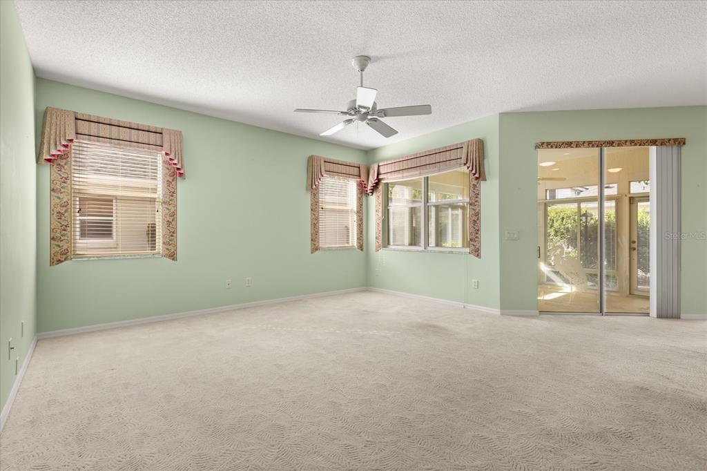 1424 Irwin Way The Villages, FL 32162 - Photo 22 of 28 an empty room with chandelier fan and windows
