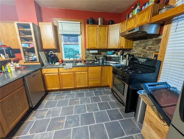 a kitchen with stainless steel appliances a stove a sink and a microwave