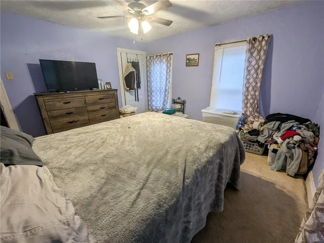 a bedroom with a bed and a flat tv screen on dresser