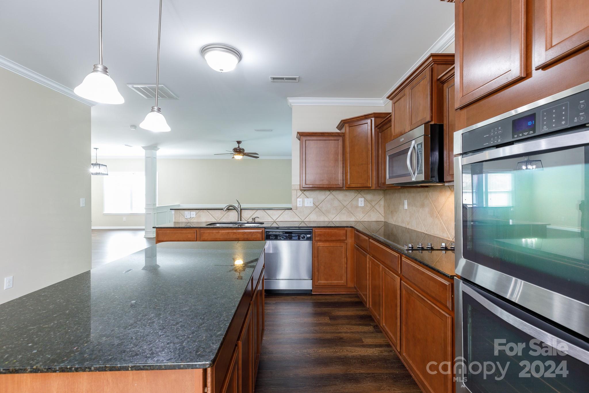 2219 Bluebell Way Fort Mill, SC 29708 - Photo 11 of 48 a kitchen with stainless steel appliances granite countertop a sink a stove and a wooden cabinets