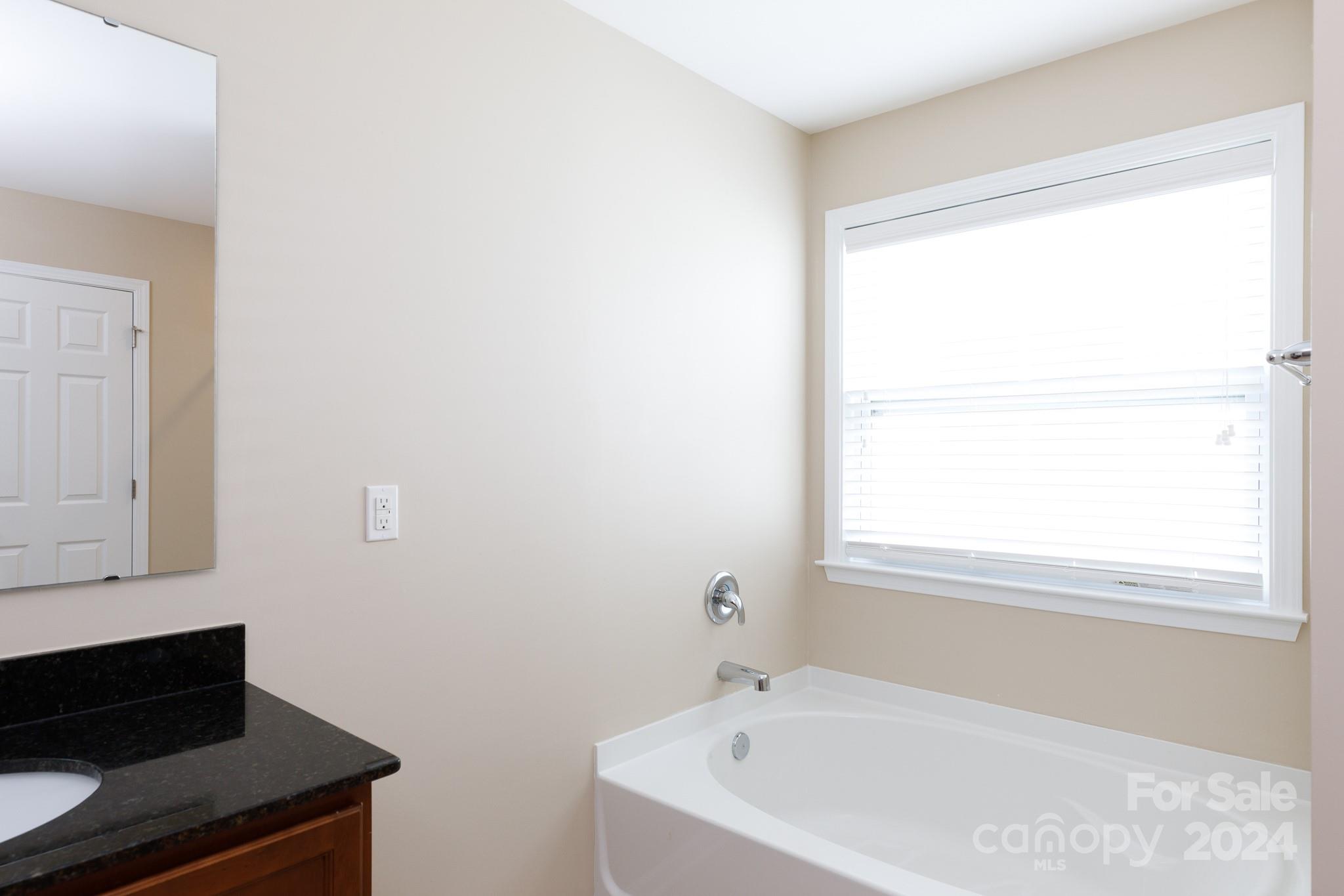 2219 Bluebell Way Fort Mill, SC 29708 - Photo 22 of 48 a bathroom with a bathtub and a window