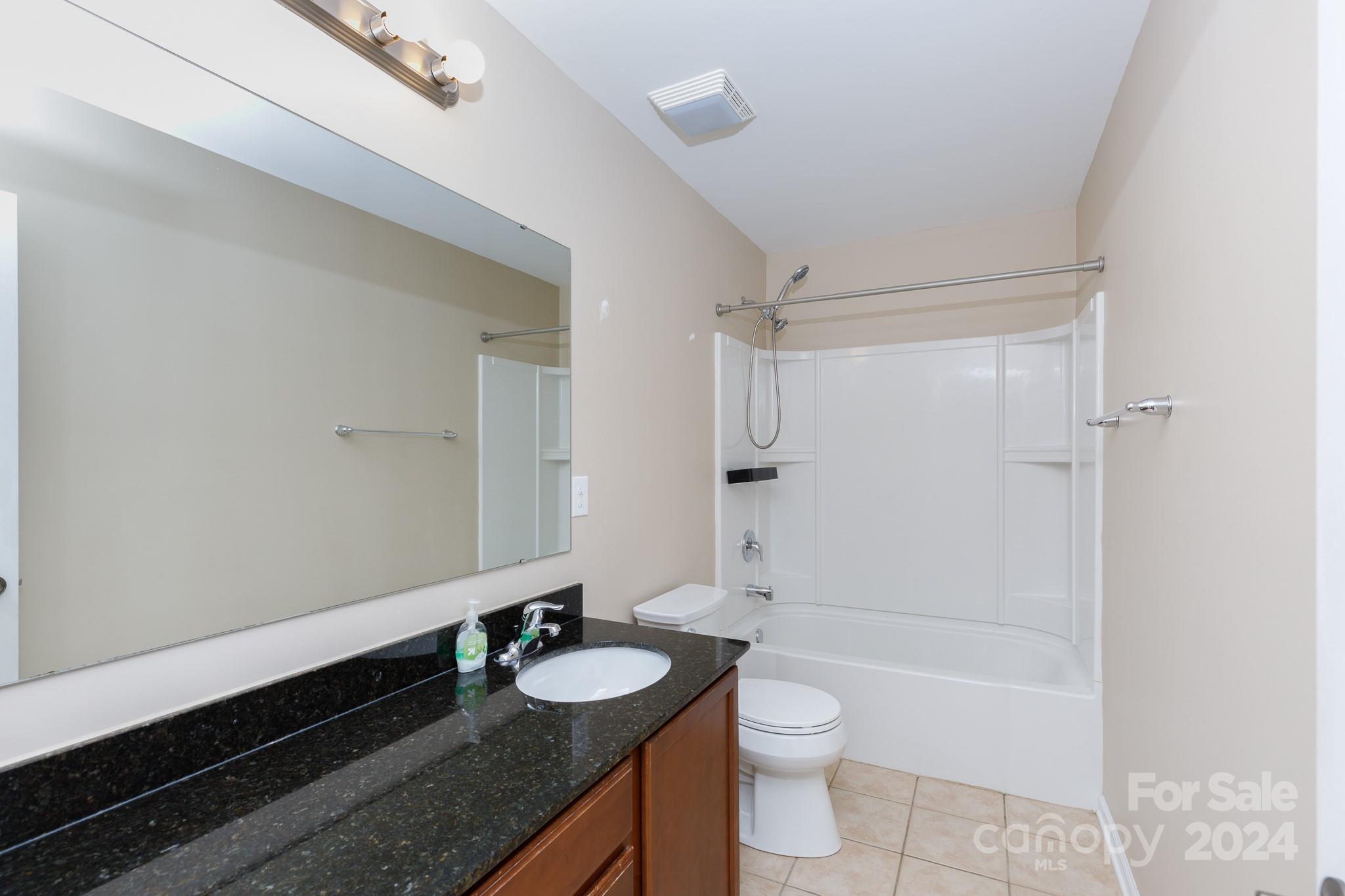 2219 Bluebell Way Fort Mill, SC 29708 - Photo 28 of 48 a bathroom with a granite countertop sink a toilet a mirror and shower