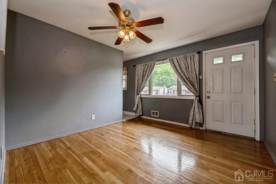 197 Princeton Road Old Bridge, NJ 08859 - Photo 4 of 25 an empty room with wooden floor and windows