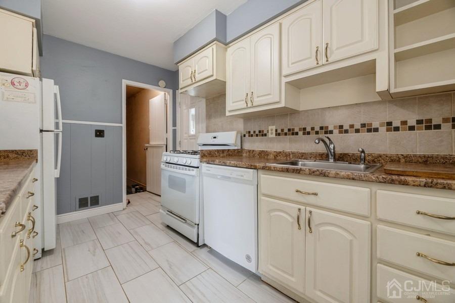 197 Princeton Road Old Bridge, NJ 08859 - Photo 6 of 25 a kitchen with granite countertop white cabinets and stainless steel appliances