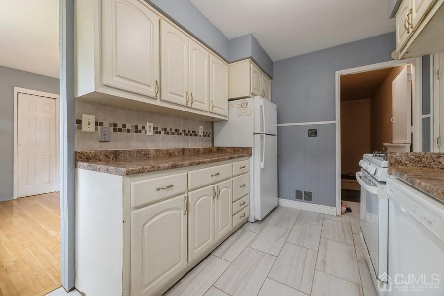 197 Princeton Road Old Bridge, NJ 08859 - Photo 7 of 25 a kitchen with granite countertop white cabinets and stainless steel appliances