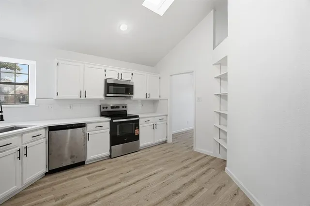 a kitchen with cabinets and wooden floor