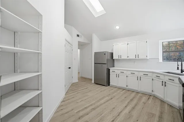 a kitchen with refrigerator cabinets and wooden floor