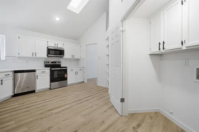 a kitchen with cabinets and wooden floor