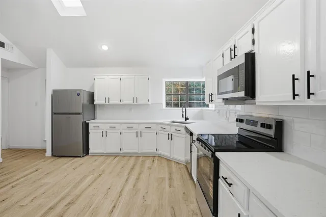 a kitchen with refrigerator cabinets and wooden floor