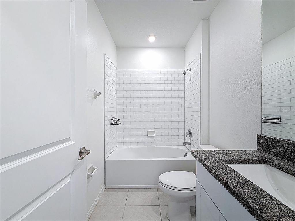 4395 Trotters Way Lakeland, FL 33801 - Photo 28 of 67 a bathroom with a granite countertop toilet a sink and bathtub