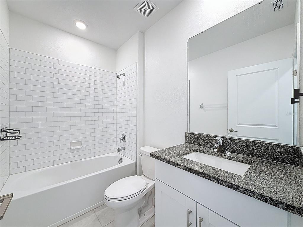 4395 Trotters Way Lakeland, FL 33801 - Photo 29 of 67 a bathroom with a granite countertop sink toilet mirror and bathtub