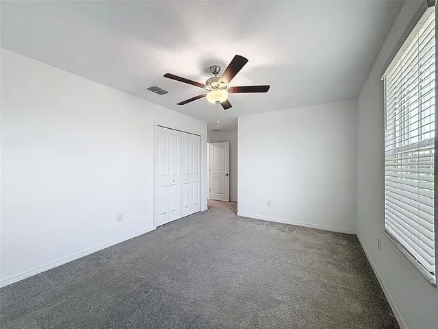 an empty room with closet and windows