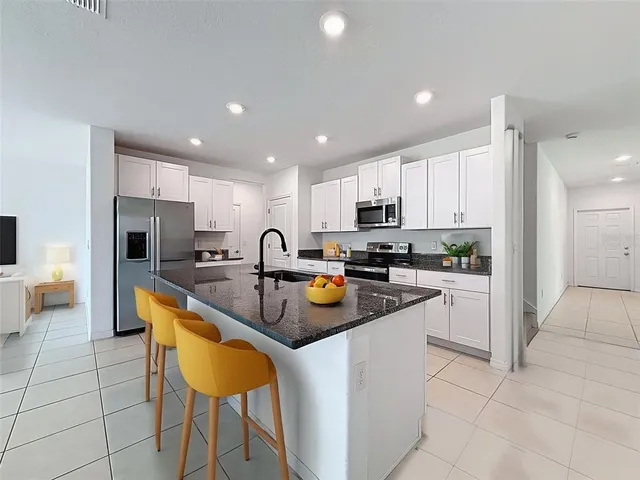 a kitchen with granite countertop a stove top oven microwave and cabinets