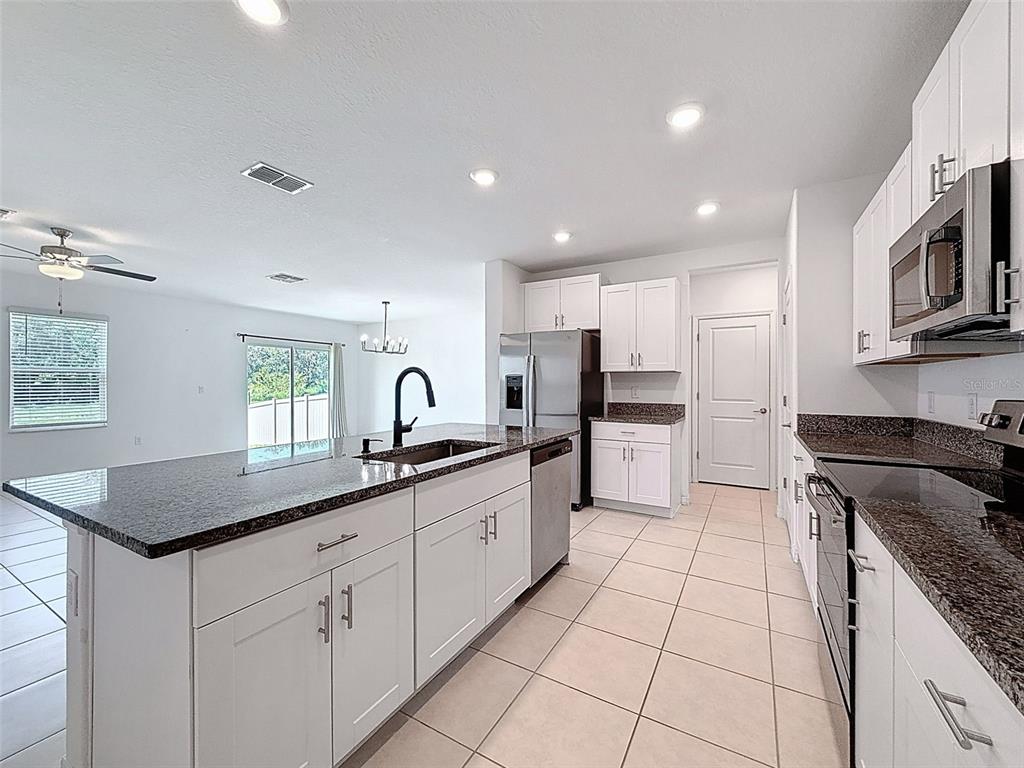 4395 Trotters Way Lakeland, FL 33801 - Photo 8 of 67 a kitchen with stainless steel appliances granite countertop a sink a stove a refrigerator and a granite counter tops