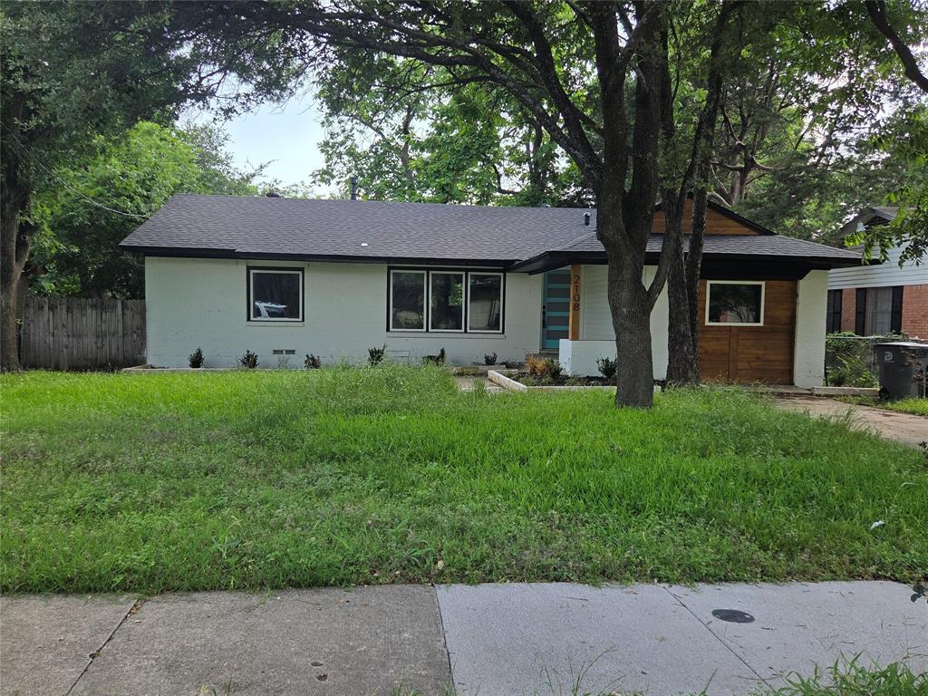 2108 Blake Avenue Dallas, TX 75228 - Photo 1 of 13 Single-story residence featuring a dark shingle roof, light-colored exterior walls, and a contrasting wood-paneled accent