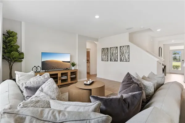 a living room with furniture a dining table and a potted plant