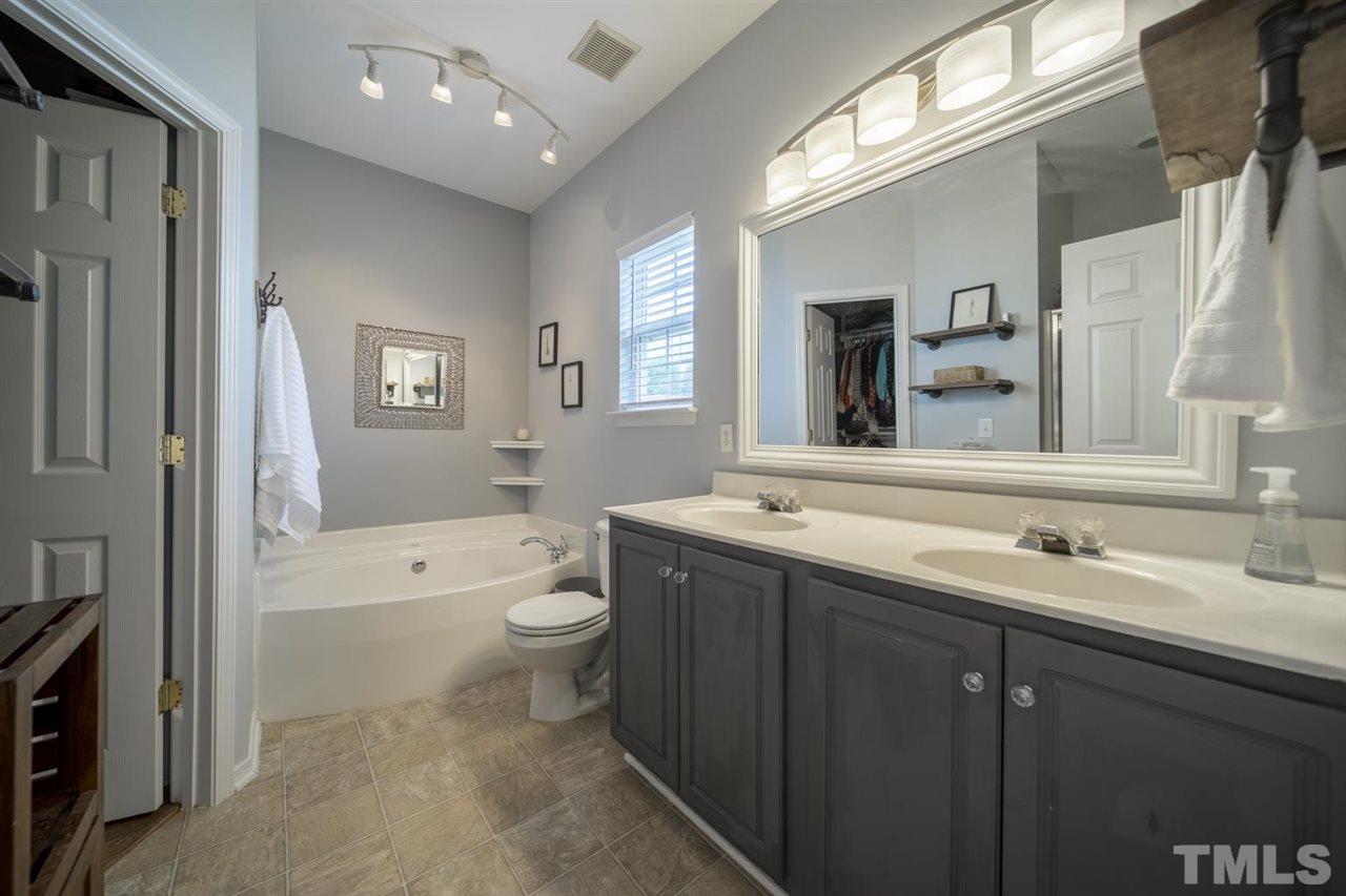 4817 Mistletoe Lane Durham, NC 27703 - Photo 11 of 15 a bathroom with a toilet a sink a tub and a mirror