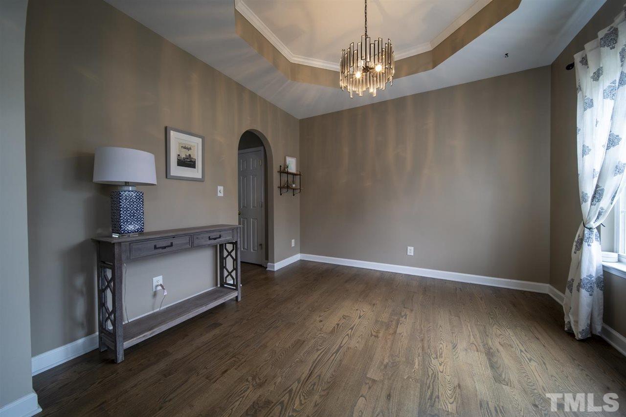 4817 Mistletoe Lane Durham, NC 27703 - Photo 3 of 15 an empty room with wooden floor cabinet and windows