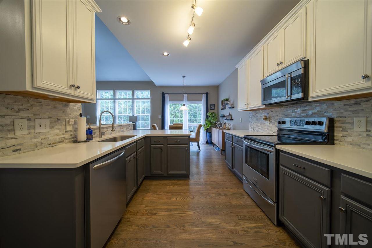 4817 Mistletoe Lane Durham, NC 27703 - Photo 6 of 15 a large kitchen with stainless steel appliances granite countertop a stove a sink dishwasher and a microwave oven with white cabinets