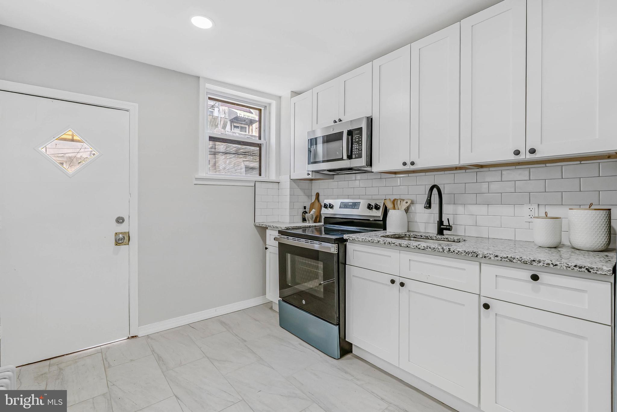 2839 Winton Street Philadelphia, PA 19145 - Photo 7 of 20 a kitchen with granite countertop white cabinets and stainless steel appliances