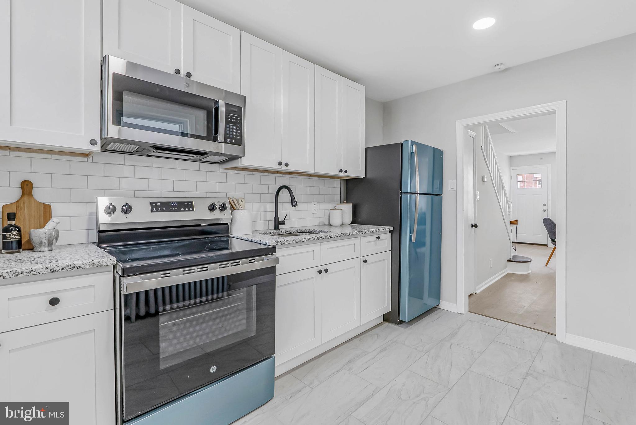 2839 Winton Street Philadelphia, PA 19145 - Photo 8 of 20 a kitchen with stainless steel appliances granite countertop a refrigerator stove and sink