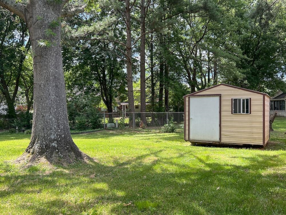 7935 Memphis Arlington Road Bartlett, TN 38133 - Photo 20 of 20 Expansive grassy yard featuring a large mature tree and a metal storage shed