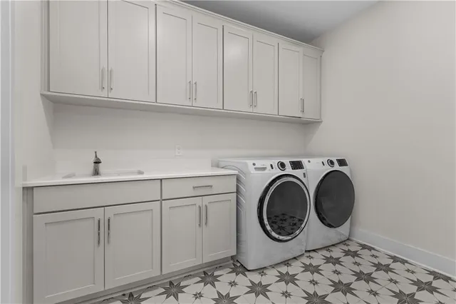 a utility room with sink dryer and washer