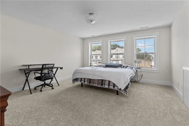 a bed sitting in a bedroom next to a window