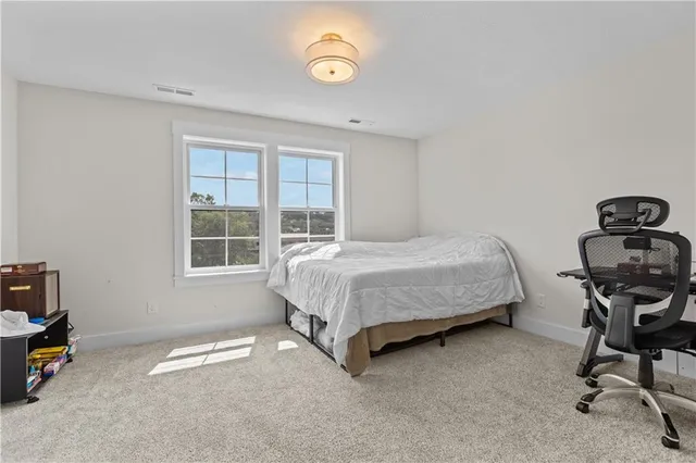 a bedroom with a bed chair and a window