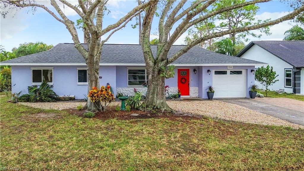 a front view of house with yard and trees around