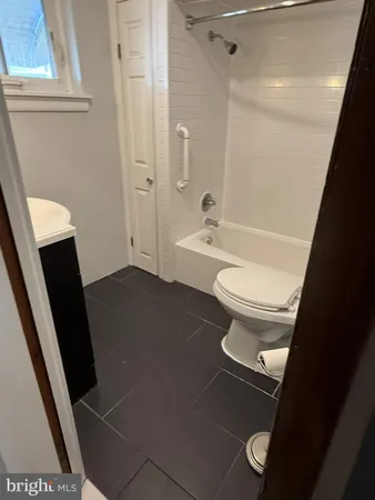 a bathroom with a sink a toilet a tub and shower