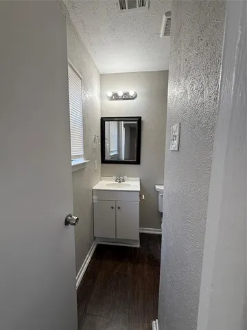 a bathroom with a toilet sink and mirror
