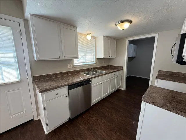 a kitchen with granite countertop a sink and cabinets