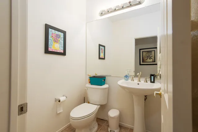 a bathroom with a toilet sink and mirror