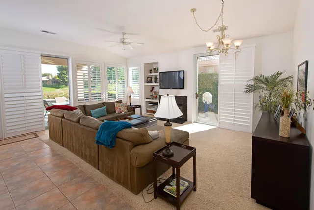 a living room with furniture a chandelier and a flat screen tv