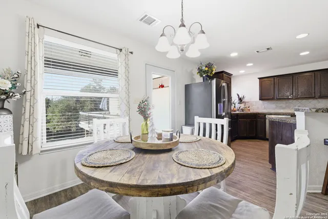 a kitchen with stainless steel appliances granite countertop a stove a kitchen island a dining table and chairs