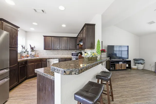 a kitchen with stainless steel appliances granite countertop a sink stove and refrigerator