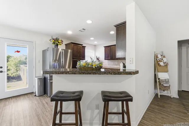 a view of a kitchen with furniture and wooden floor