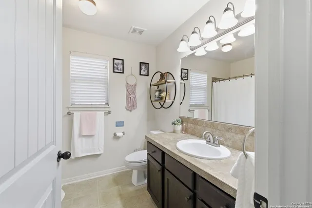 a bathroom with a sink a toilet and a mirror