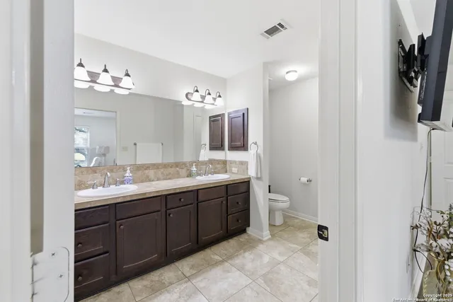 a bathroom with a double vanity sink and a toilet