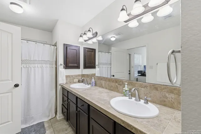 a bathroom with a granite countertop sink and a mirror
