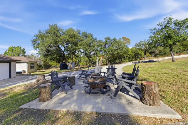 a view of a patio with table and chairs potted plants and a large tree