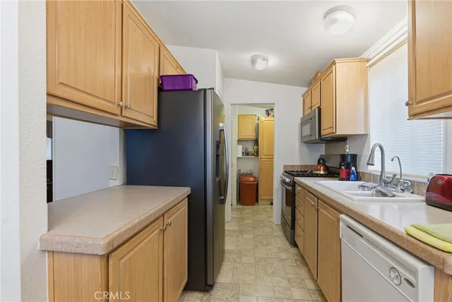a kitchen with a sink a stove and a refrigerator
