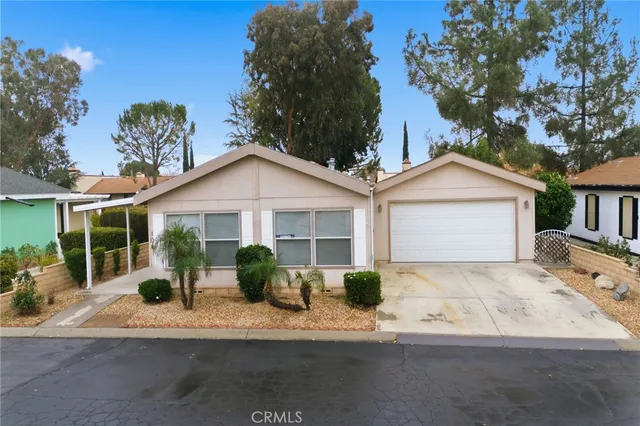 a front view of a house with a yard and potted plants