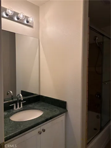a bathroom with a granite countertop sink and toilet
